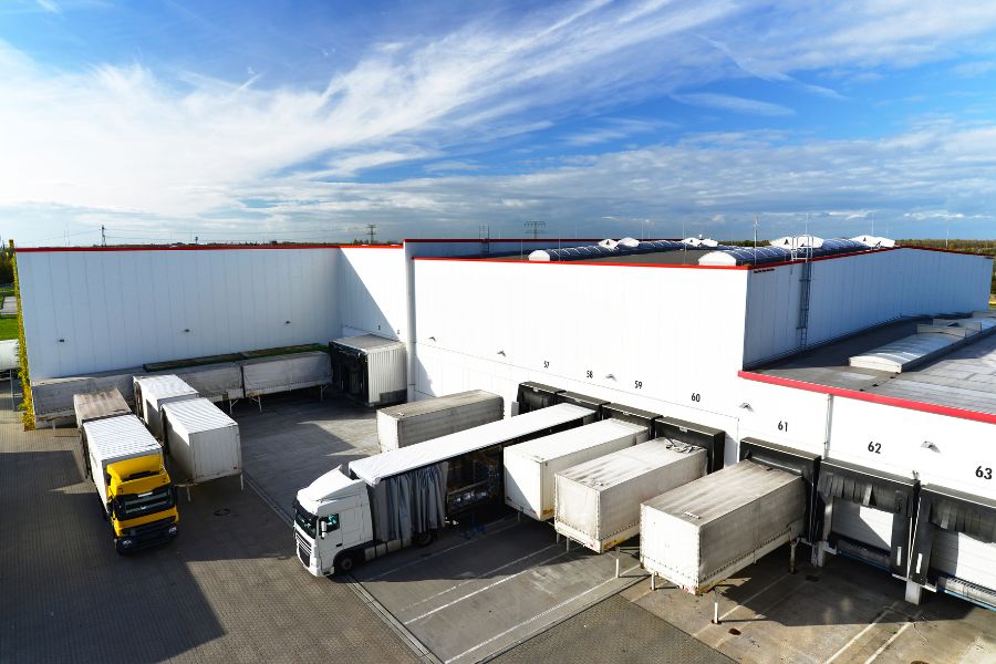 trucks docked at warehouse to have containers loaded to deliver products through the supply chain