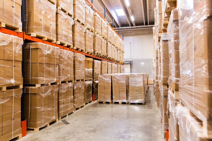 overcrowded warehouse with pallets on the floor blocking the aisle