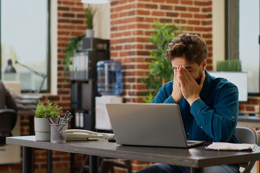 Supply chain manager at desk weary from supply chain challenges