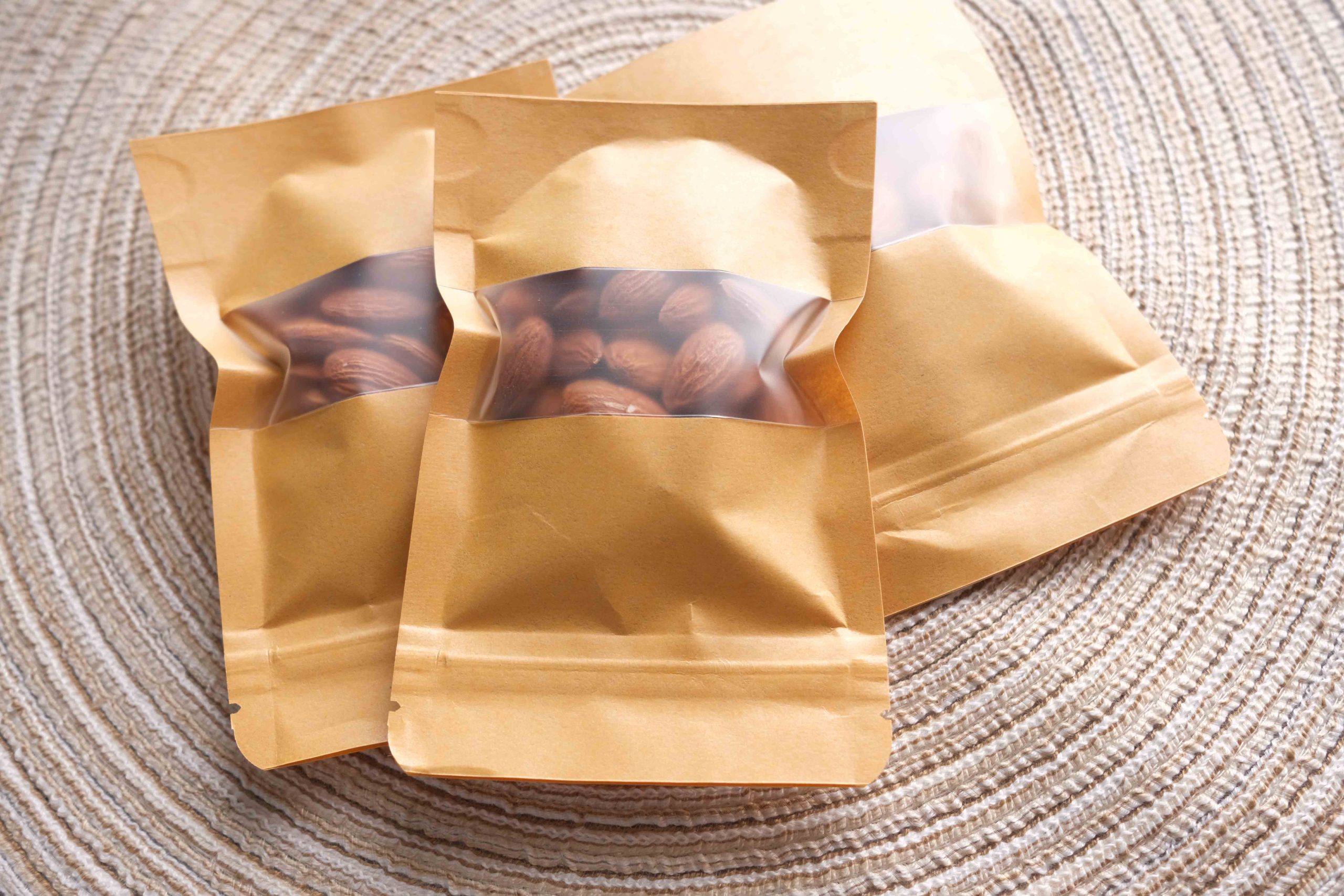 Sealed brown pouch with a window showing almonds inside