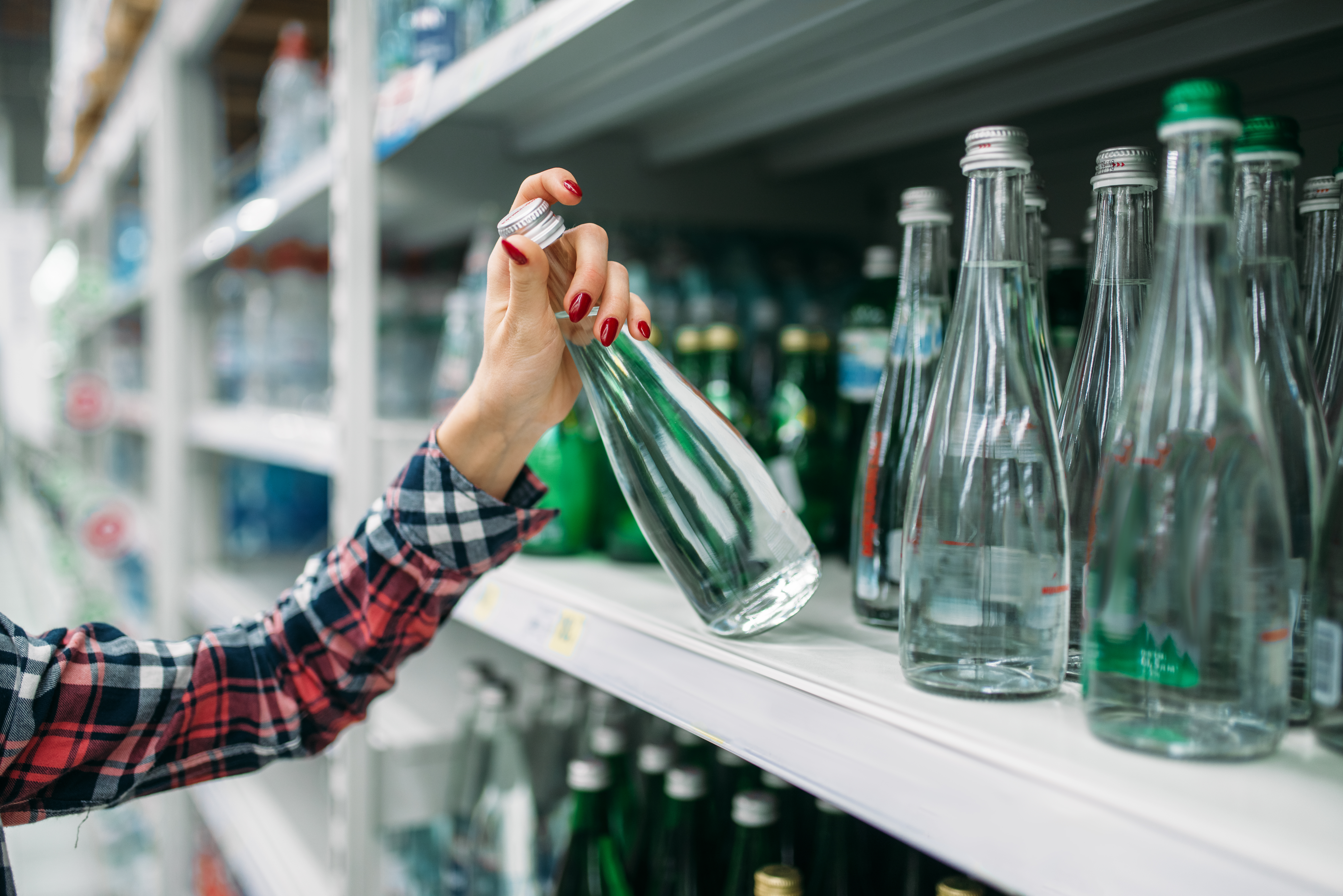 Customer picking a glass beverage bottle