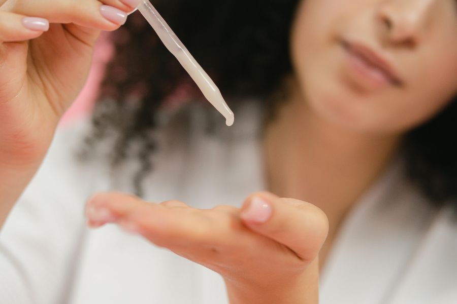 Person applies product to skin through a dropper