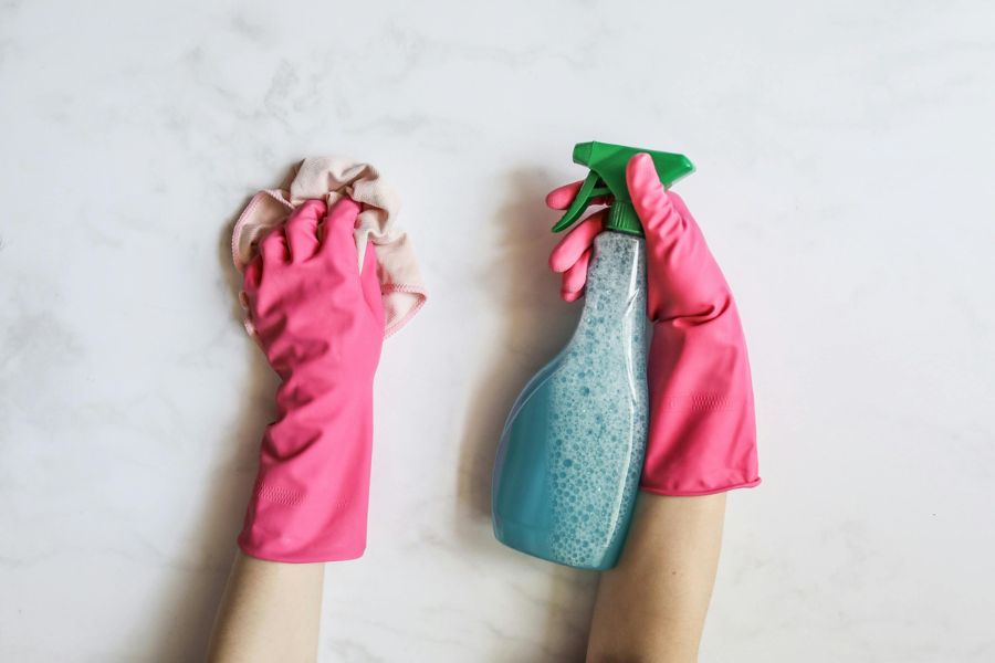 Person applies cleaning product to surface using a spray bottle