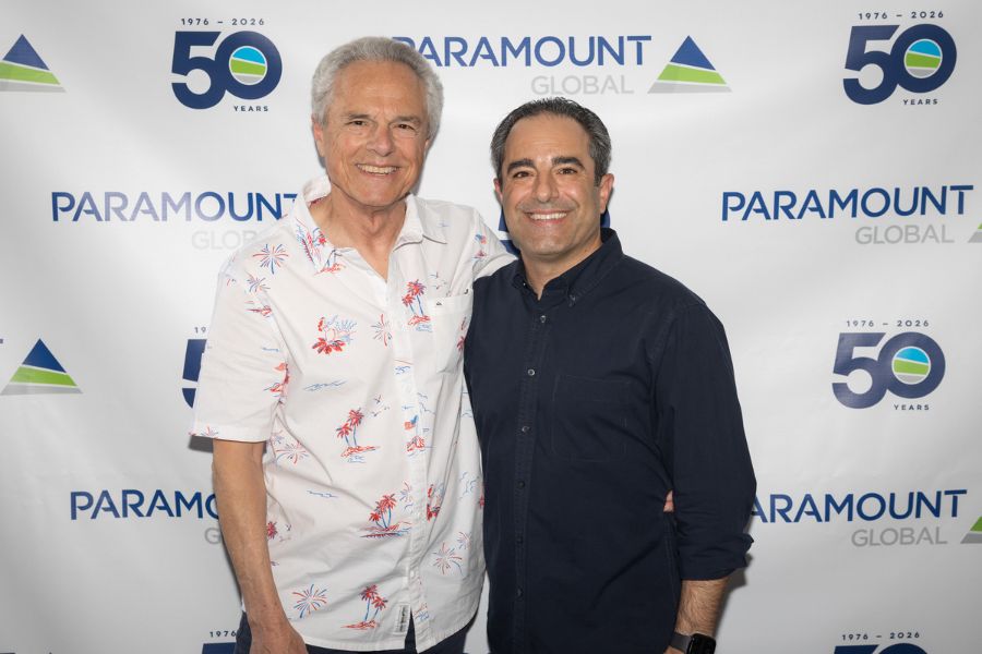 Paramount Global Founder, Jack Gample (left), and his son, Paramount's current president, Jay Gample (right) pose for photo in front of 50 year backdrop.