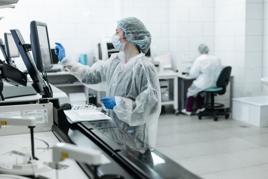 Person in protective gear testing packaging in a facility